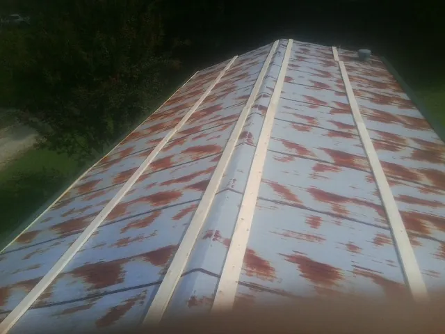 Rusted metal roof panels with new wood purlins before replacement — Storm Damage Roof Repair in Monterey Park by Roofing Brothers