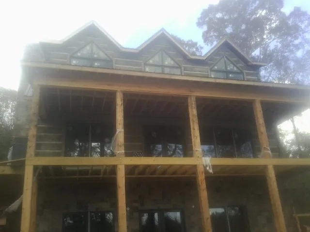 Dormers and porch framing on a large log home under construction — Roof Coating work by our crew in Monterey Park